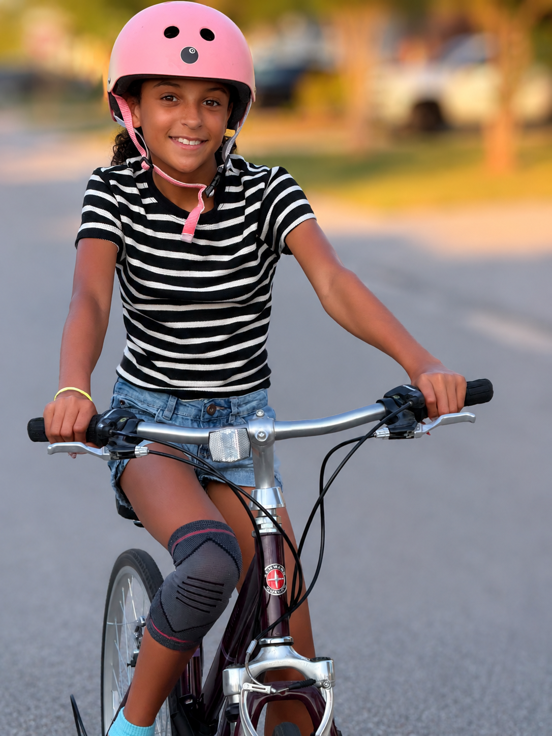 Child wearing a bicycle helmet while riding a bike during summer activities.