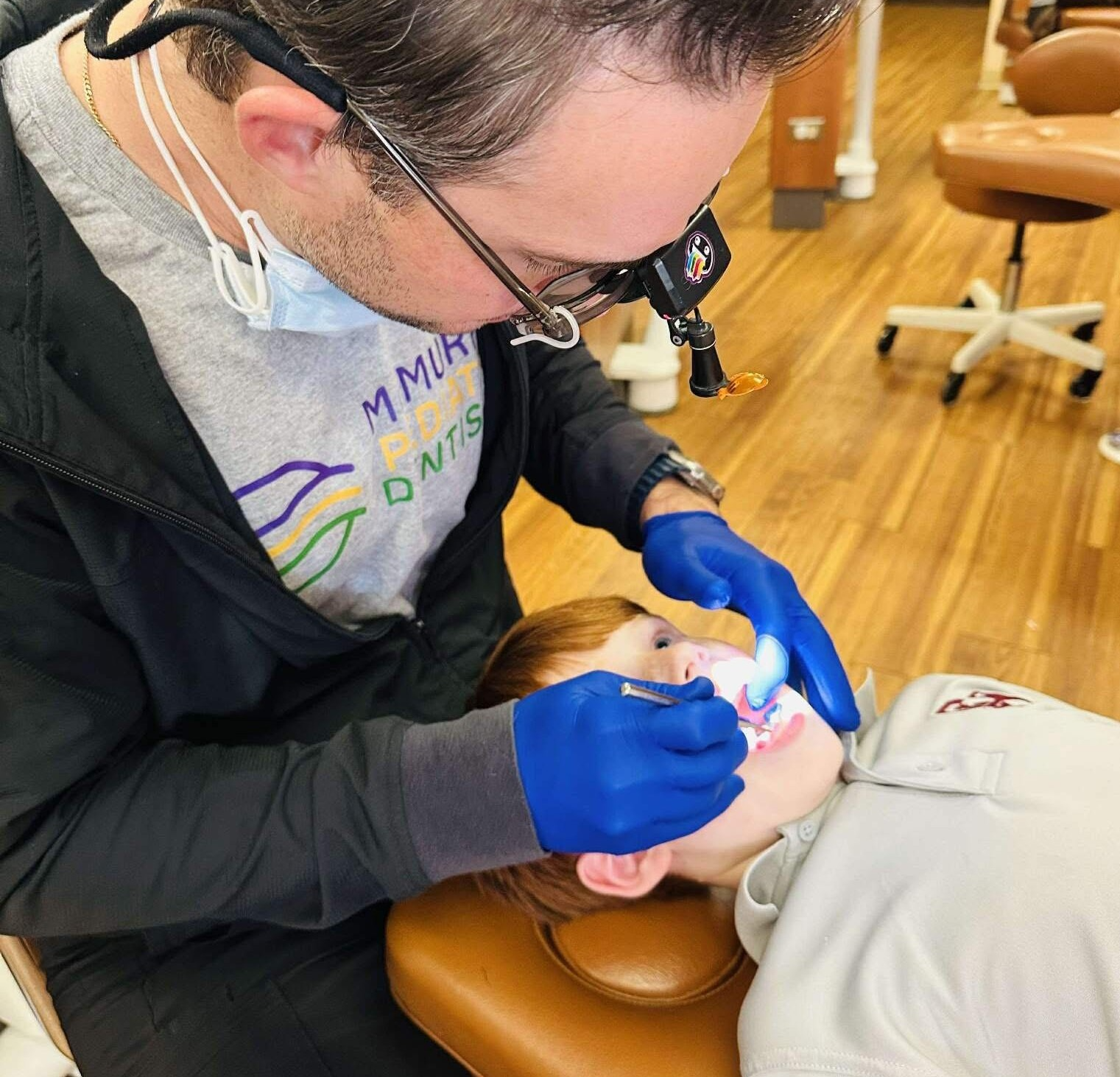 Dr. Austin McMurphy examining a young patient during a pediatric dental visit at McMurphy Pediatric Dentistry in Biloxi, Mississippi.